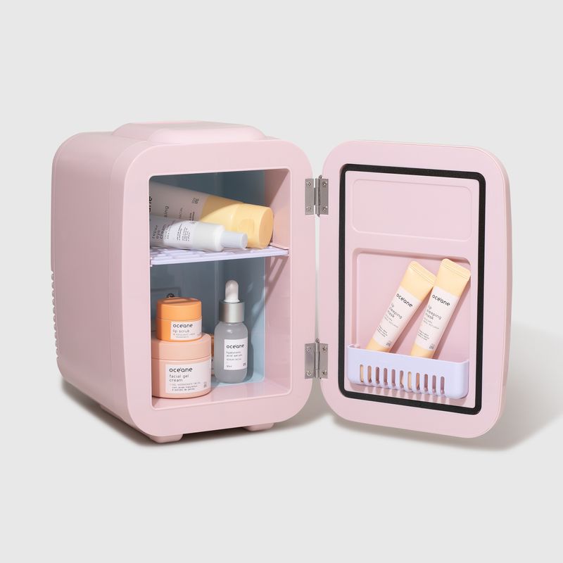Mini Geladeira Rosa de Skincare Fridge 4l Océane aberta, com os produtos de skincare dentro da mini geladeira