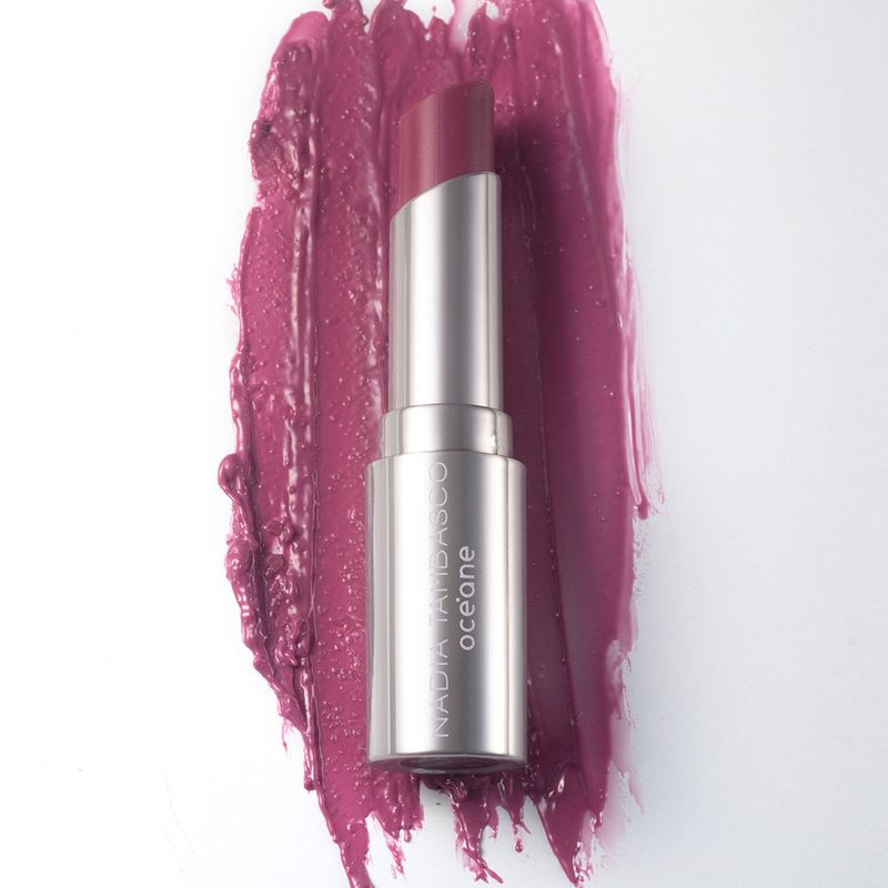 Revitalizador Labial Roxo Nádia Tambasco By Océane Sweet Lips Punchy, embalagem aberta frete com textura ao fundo