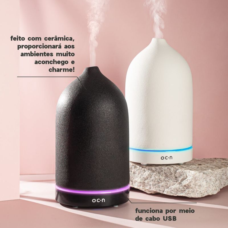 Difusor de Aromas Preto dois difusores vistos de frente, um preto e um branco, com duas setas explicativas, uma dizendo que eles são feitos de cerâmica e outra que eles funcionam através de cabo USB